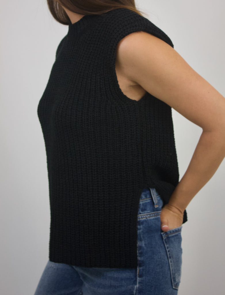 black sleeveless knit top with slit and shoulder pads
