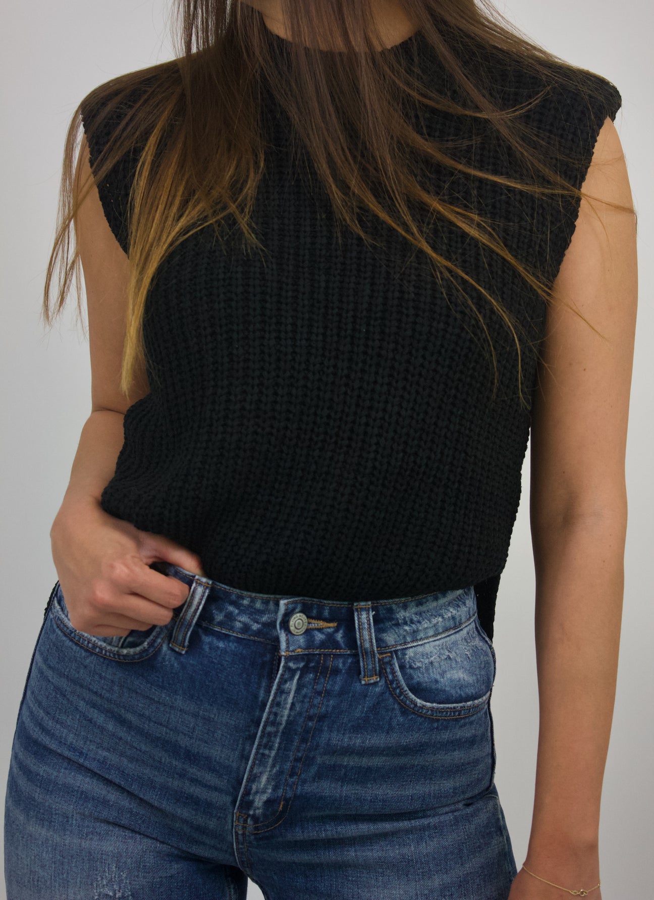 black sleeveless knit top with slit and shoulder pads
