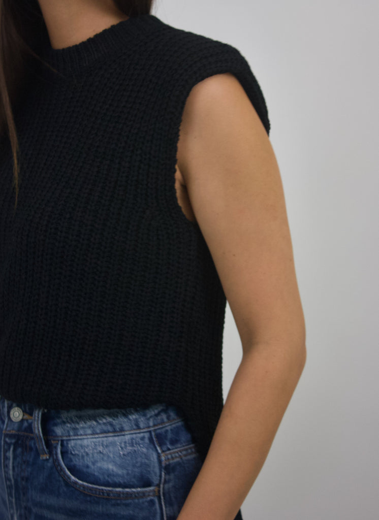 black sleeveless knit top with slit and shoulder pads